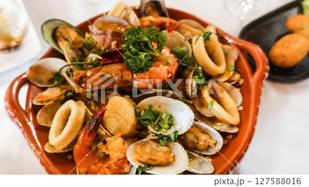 close up of Portuguese Arroz de Marisco, tomato brothy seafood rice on a red plate taken in a restaurant in Macau close up of Portuguese Arroz de Marisco, tomato brothy seafood rice on a red plate taken in a restaurant in Macau 127588016