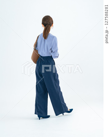 カジュアルウェアを着て歩く女性の後ろ姿の全身写真 127588281