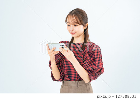 スマホを見るカジュアルウェアの女性 127588333