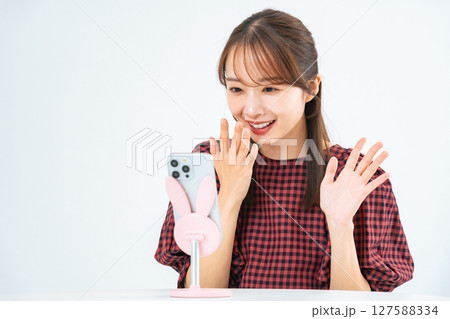 スマホでライブ動画配信をする女性 スマホでライブ動画配信をする女性 127588334