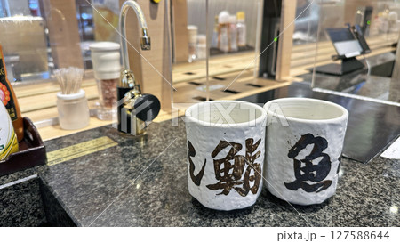 回転寿司に設置された給湯レバーと湯呑 回転寿司に設置された給湯レバーと湯呑 127588644