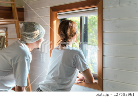 グランピングのコテージで窓の外を見つめる夫婦,カップル グランピングのコテージで窓の外を見つめる夫婦,カップル 127588961