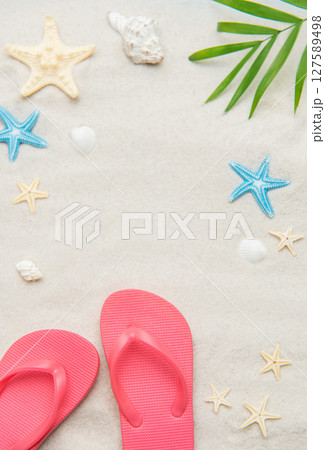 Pink flip flops, seashells, and starfishes creating relaxing summer beach background 127589498