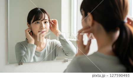 鏡の前で身支度をする若い女性 127590493