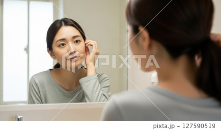 鏡の前で身支度をする若い女性 127590519