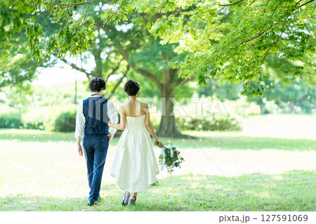 腕を組んで歩く新郎新婦の後ろ姿 127591069