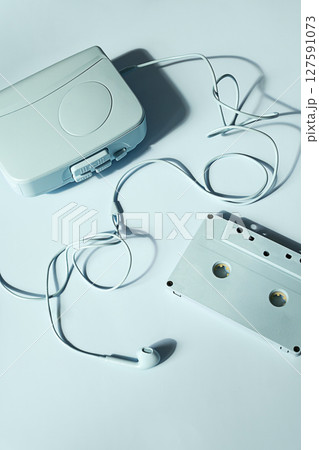 Portable Music Player Earphone and Cassette Tape on Light Blue Background. Retro Audio Technology Concept. 127591073