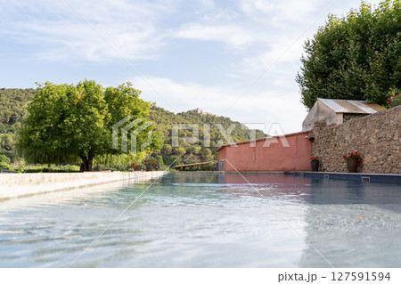 Pool scenery with hills, trees, clear blue sky for a peaceful outdoor escape Pool scenery with hills, trees, clear blue sky for a peaceful outdoor escape 127591594