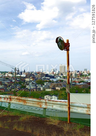 夏の仙台の市街地とカーブミラーのある風景を丘から望む 夏の仙台の市街地とカーブミラーのある風景を丘から望む 127591826