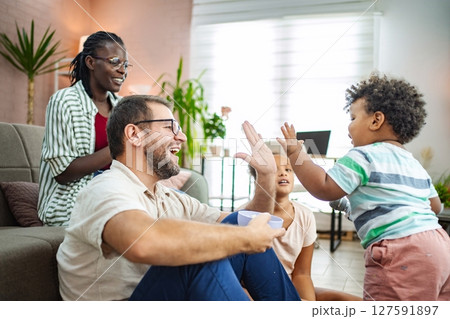 Family joy during playtime in a cozy living room 127591897