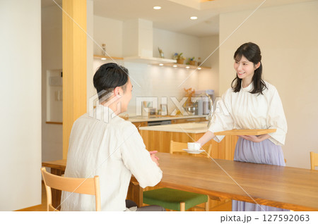 リビングでコーヒーを渡す日本人女性 127592063