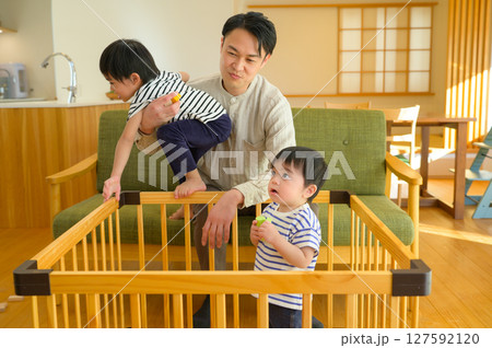 ケージで遊ぶ幼い兄弟と父親 ケージで遊ぶ幼い兄弟と父親 127592120