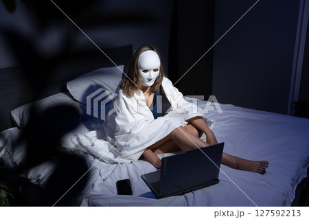 Person in Mask Using Laptop on Bed to Protect Data From Online Threats 127592213
