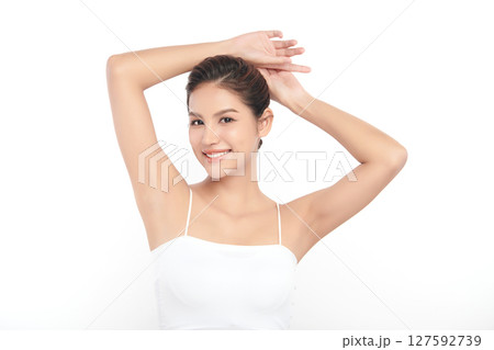Beautiful Young Asian woman Raises her hands to Showcase clean and hygienic underarms Against a white background, Smooth armpit cleanliness and protection concept 127592739