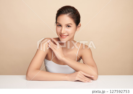 A beautiful young Asian woman with clean, fresh skin against a beige background. Skincare, facial treatment, cosmetology, beauty, and spa. An elegant portrait of an Asian woman. A beautiful young Asian woman with clean, fresh skin against a beige background. Skincare, facial treatment, cosmetology, beauty, and spa. An elegant portrait of an Asian woman. 127592753