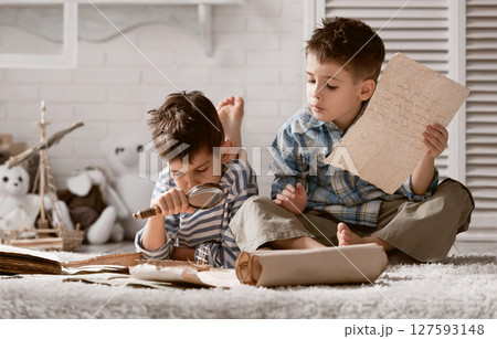Two boys studying old maps Travel 127593148