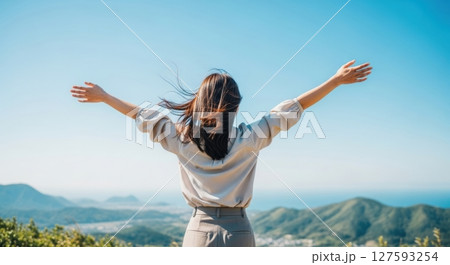 女性が山頂で両手を広げる写真 127593254