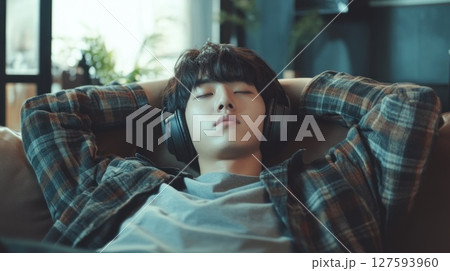 Person wear headphone sit on sofa 127593960
