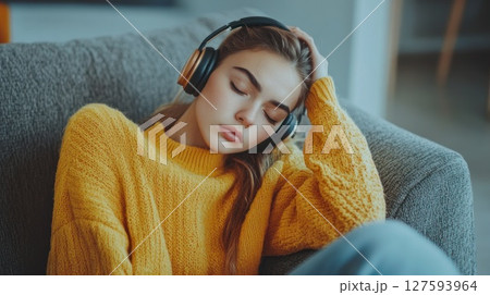 Person wear headphone sit on sofa 127593964