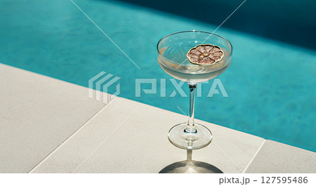 Chill vibes by the pool with a refreshing drink paired with a dried citrus slice Chill vibes by the pool with a refreshing drink paired with a dried citrus slice 127595486