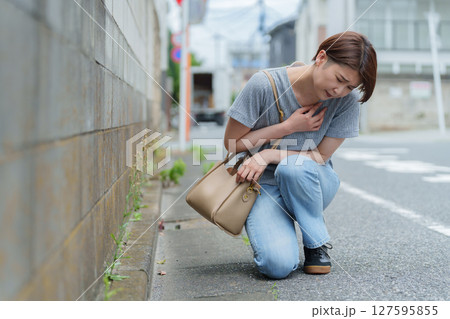 体調不良でうずくまる女性 127595855