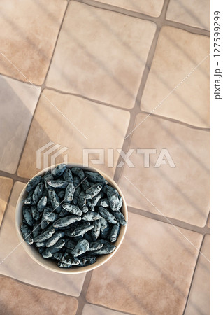 Bowl Full of Honeysuckle Berry on Tile Surface. Healthy Eating and Delicious Snack. 127599299