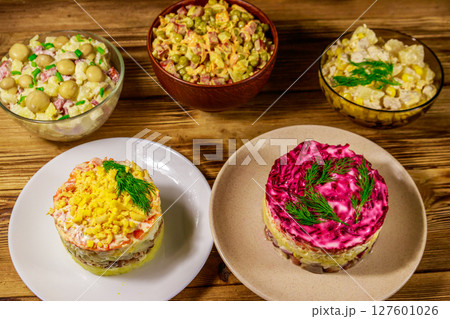 Set of festive mayonnaise salads on wooden table 127601026