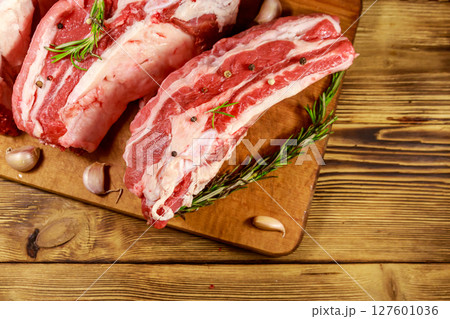 Raw pork ribs with spices, garlic and rosemary on wooden table. Top view Raw pork ribs with spices, garlic and rosemary on wooden table. Top view 127601036