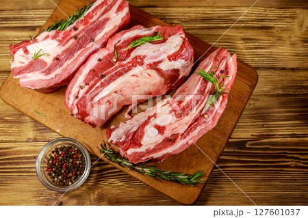 Raw pork ribs with spices and rosemary on wooden table. Top view 127601037