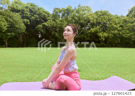天然芝と青空の下、リゾート気分でヨガ&ピラティスをする女性 天然芝と青空の下、リゾート気分でヨガ&ピラティスをする女性 127601425