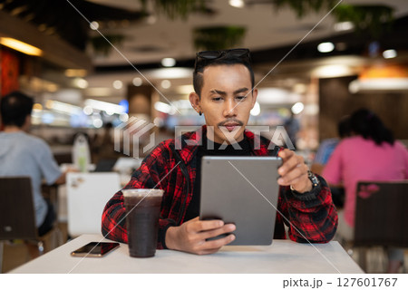 Portrait of nonbinary genderfluid young Asian gay man using digital tablet computer Portrait of nonbinary genderfluid young Asian gay man using digital tablet computer 127601767