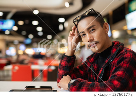 Portrait of nonbinary genderfluid young Asian gay man in restaurant 127601778