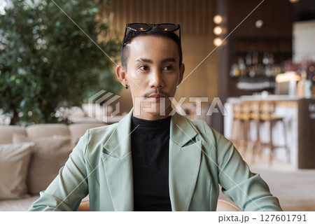 Portrait of nonbinary genderfluid young Asian gay man in coffee shop Portrait of nonbinary genderfluid young Asian gay man in coffee shop 127601791