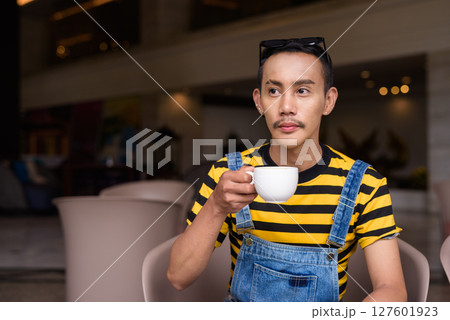 Portrait of nonbinary genderfluid young Asian gay man in coffee shop Portrait of nonbinary genderfluid young Asian gay man in coffee shop 127601923