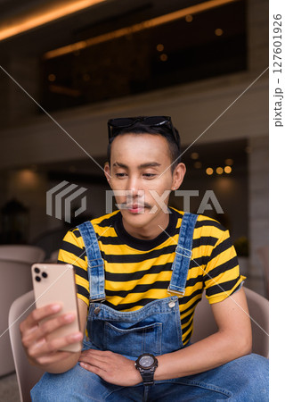 Portrait of nonbinary genderfluid young Asian gay man in coffee shop 127601926