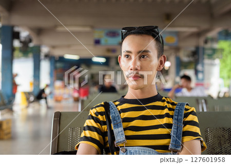 Portrait of nonbinary genderfluid young Asian gay tourist man in bus terminal Portrait of nonbinary genderfluid young Asian gay tourist man in bus terminal 127601958