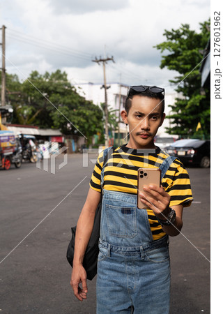 Portrait of nonbinary genderfluid young Asian gay tourist man in bus terminal walking 127601962