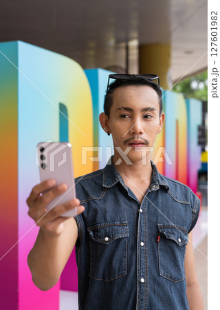 Portrait of confident non binary gay man during pride outdoors 127601982