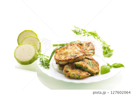 fried zucchini pancakes with green onions in a plate on a white background fried zucchini pancakes with green onions in a plate on a white background 127602064