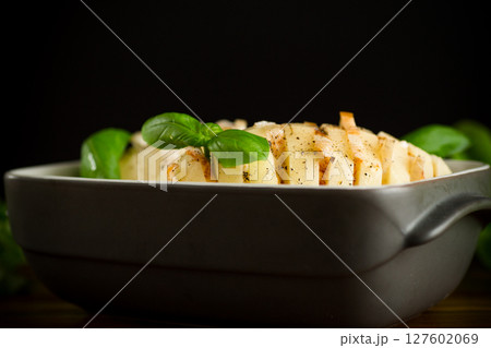 Sliced potatoes in a baking dish 127602069