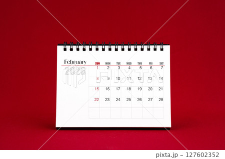 February 2026 Blank desk calendar on red color background. 127602352