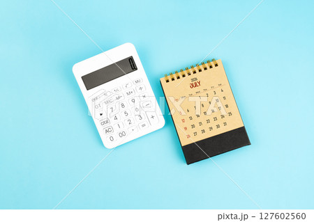 July 2026 brown caculator and white calculator on blue color background. 127602560