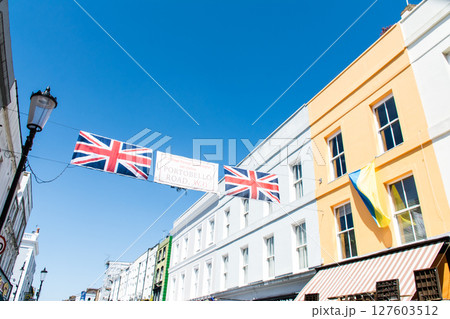 真っ青な快晴の空の下のカラフルな建物と飾られたユニオンジャックの旗　ロンドンのポートベローにて 127603512