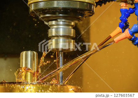 Close up scene the CNC milling machine finishing cut the brass shell mold parts with oil coolant method. Close up scene the CNC milling machine finishing cut the brass shell mold parts with oil coolant method. 127603567