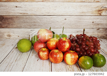 Various of fruits with Red grape, red apple and green orange on wooden background Various of fruits with Red grape, red apple and green orange on wooden background 127603942