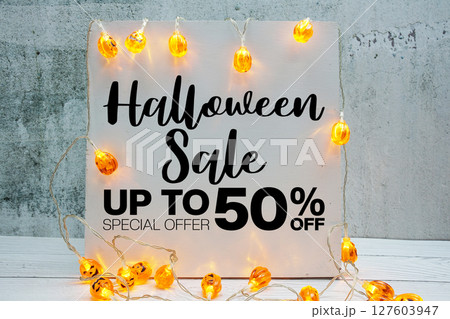 Halloween Sale 50% off text with LED pumpkin decoration on wooden background 127603947