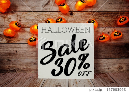 Halloween Sale 30% off text with LED pumpkin decoration on wooden background 127603968