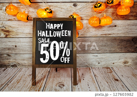 Halloween Sale 50% off text with LED pumpkin decoration on wooden background Halloween Sale 50% off text with LED pumpkin decoration on wooden background 127603982