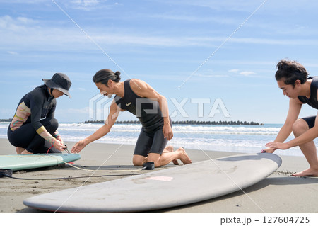 サーフィン前の準備を丁寧に教えるインストラクター 127604725