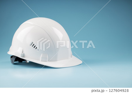 White safety helmet on a blue background with free space 127604928